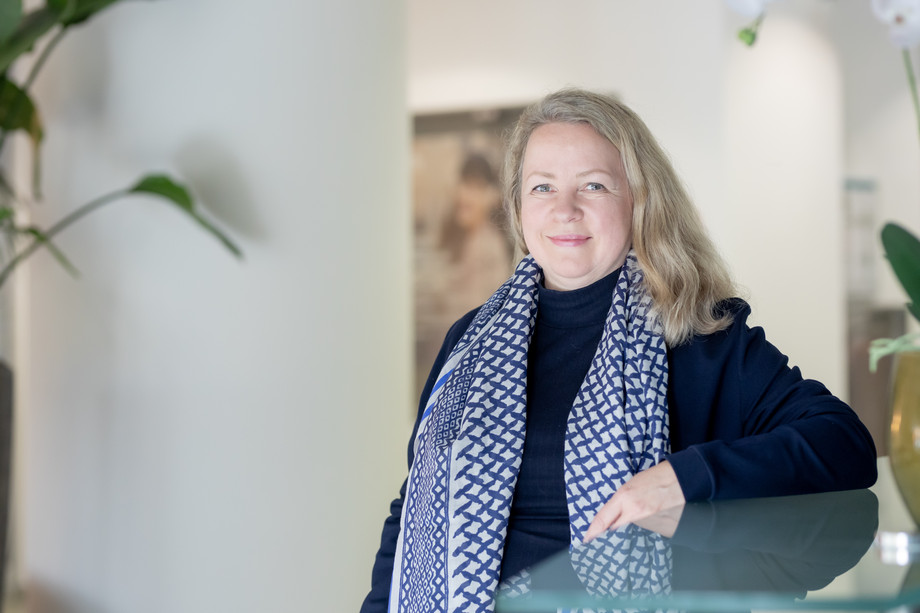 Lächelnde blonde Frau in blauer Kleidung