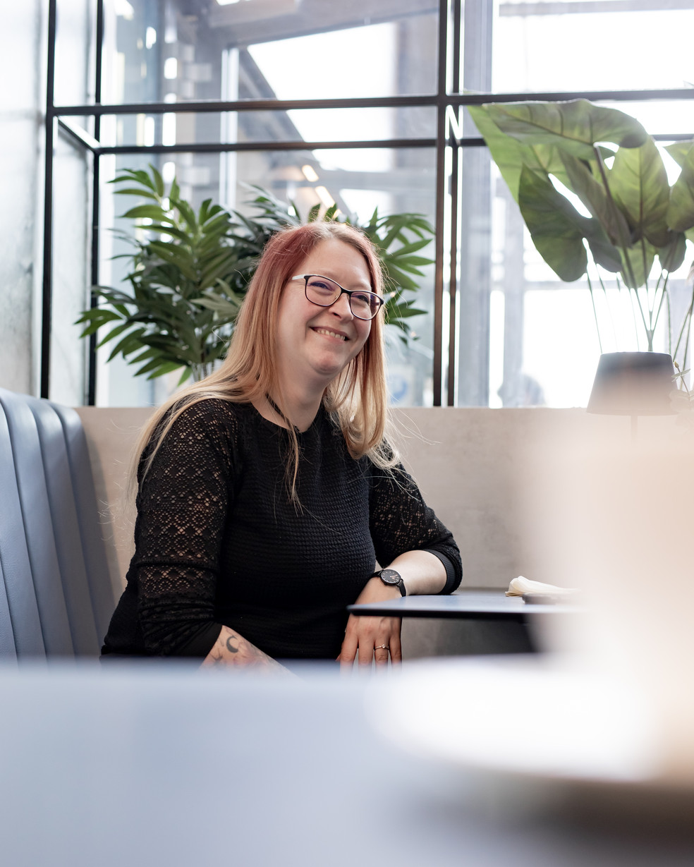 eine Frau in schwarzer Bluse sitzt in einem Café
