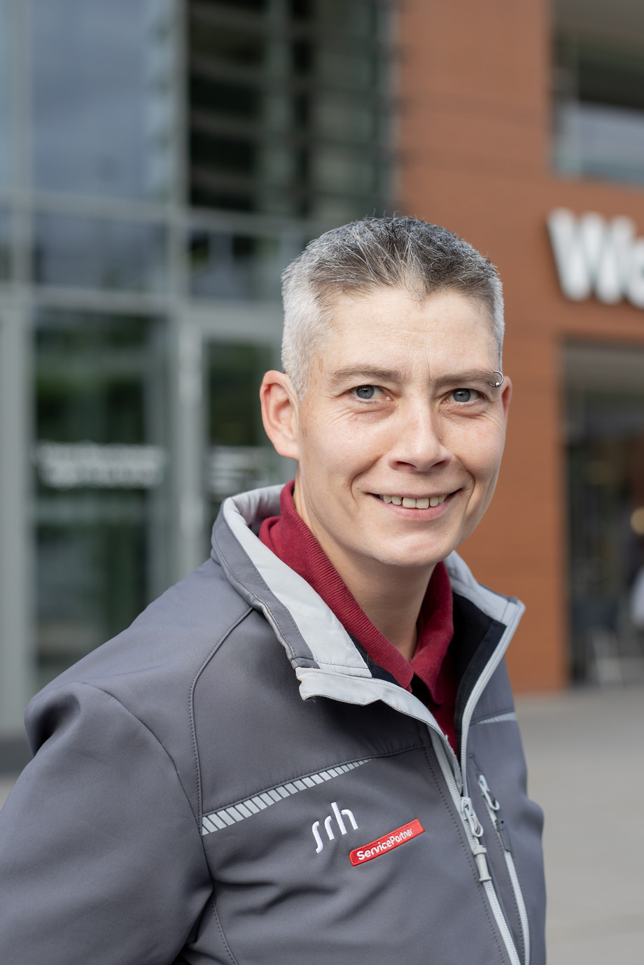 Eine Frau steht vor einem Gebäude mit der Aufschrift "Wald-Klinikum Gera".