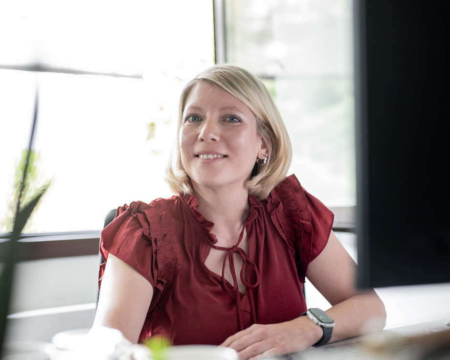 Junge Frau in roter Bluse an einem Tisch